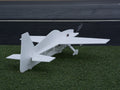 Model airplane on a grassy surface with a dark background