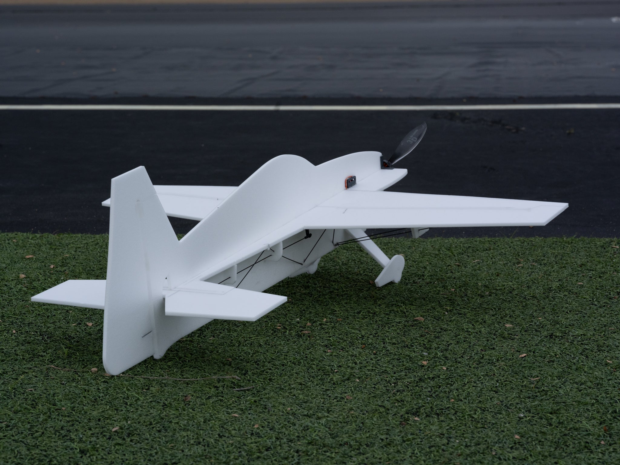 Model airplane on a grassy surface with a dark background