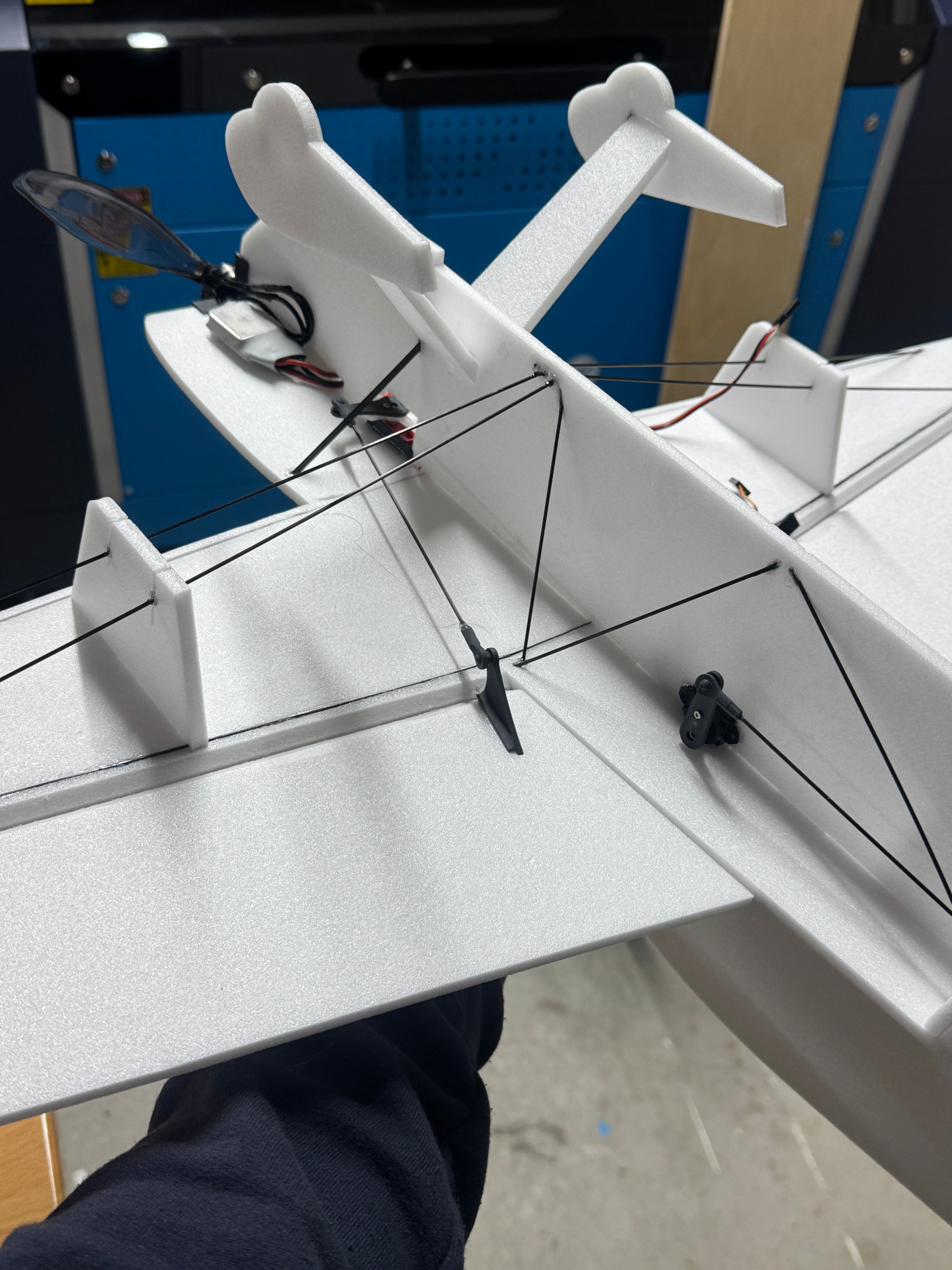 Close-up of a white foam model airplane model with visible struts and control surfaces.