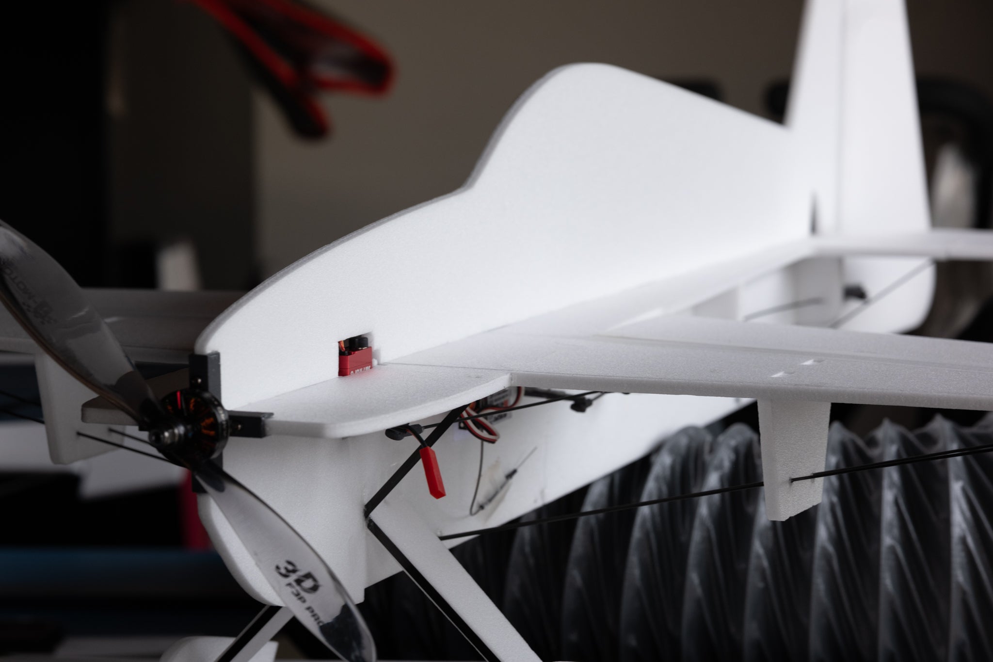 Close-up of a white foam model airplane with visible branding on a blurred background