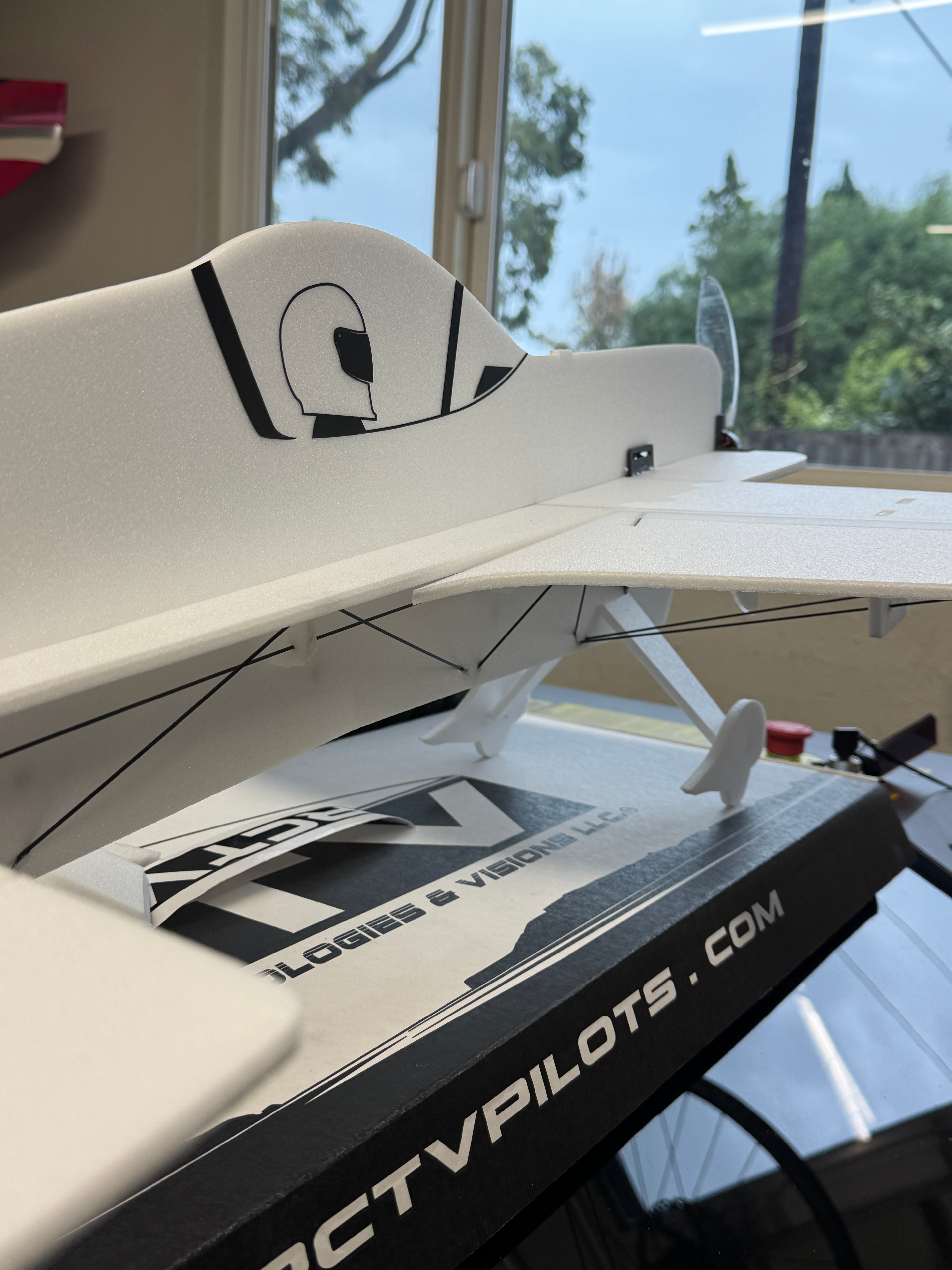Close-up of a white and black airplane model with 'Flight Pilot' branding inside a building.