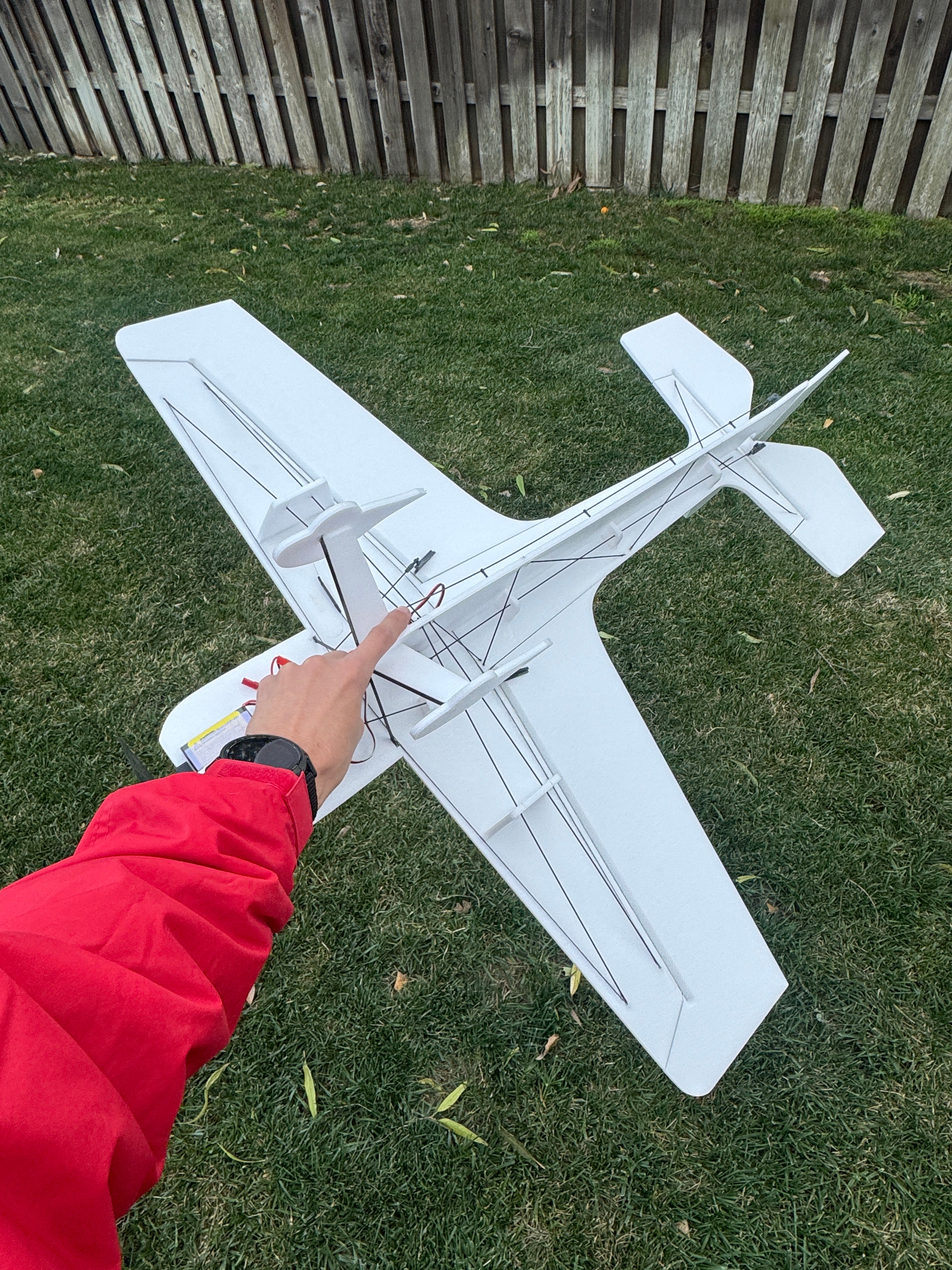 Model airplane on grass with a person's hand touching it